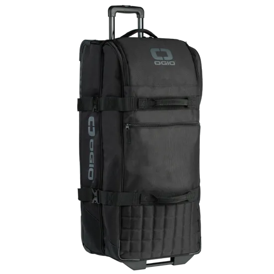 Черен сак OGIO TRUCKER с телескопична дръжка, колела и множество джобове с цип, показващ здрав 900D материал и лого OGIO