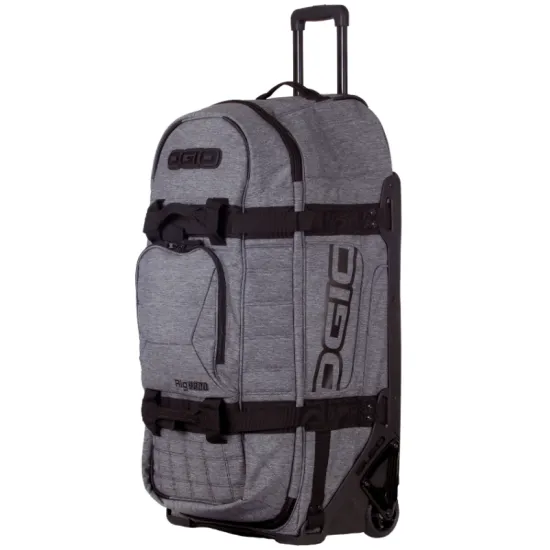 Сив меланжов сак OGIO RIG 9800 Dark Static с черна телескопична дръжка, големи колела и множество джобове, показан отворен с червена вътрешност и мотоекипировка вътре