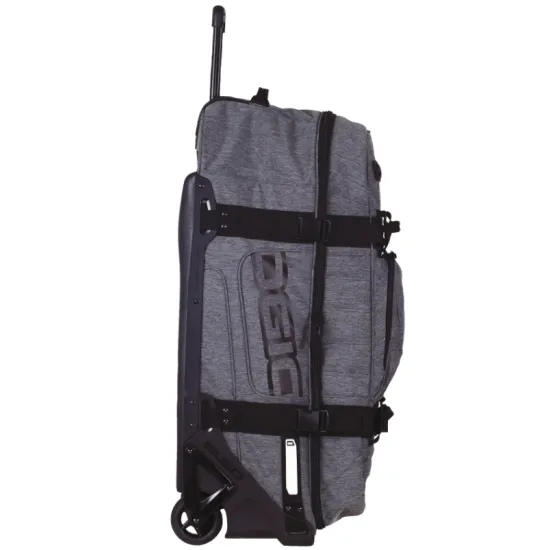 Сив меланжов сак OGIO RIG 9800 Dark Static с черна телескопична дръжка, големи колела и множество джобове, показан отворен с червена вътрешност и мотоекипировка вътре