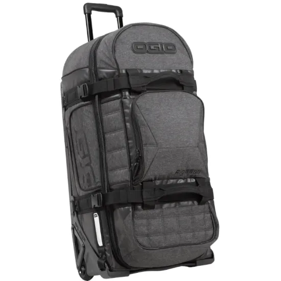 Сив меланжов сак OGIO RIG 9800 Dark Static с черна телескопична дръжка, големи колела и множество джобове, показан отворен с червена вътрешност и мотоекипировка вътре