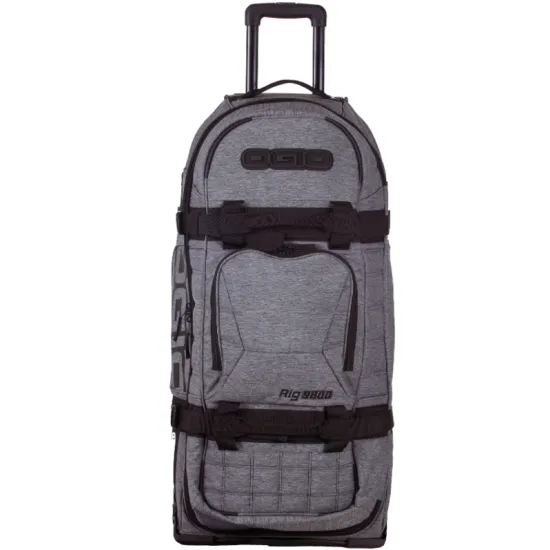 Сив меланжов сак OGIO RIG 9800 Dark Static с черна телескопична дръжка, големи колела и множество джобове, показан отворен с червена вътрешност и мотоекипировка вътре
