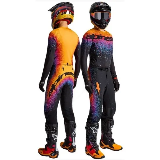 Черен мотокрос брич Alpinestars с ярко градиентно оцветяване от оранжево-жълто до синьо-черно, със спрей ефект и оранжева звезда, показан от предна и задна страна на модели с каски