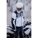 Бяло мото яке ICON Merc3 ANOMALY с черни графични елементи, носено от мотоциклетист с бяла каска седнал на бял мотор
