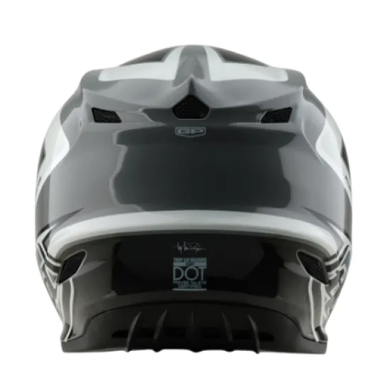 Сиво-бяла мотокрос каска Troy Lee Designs GP Shutter с геометричен дизайн, TLD лого и удължен визьор, показана от профил и отгоре