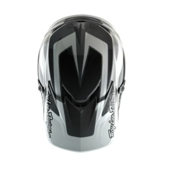 Сиво-бяла мотокрос каска Troy Lee Designs GP Shutter с геометричен дизайн, TLD лого и удължен визьор, показана от профил и отгоре