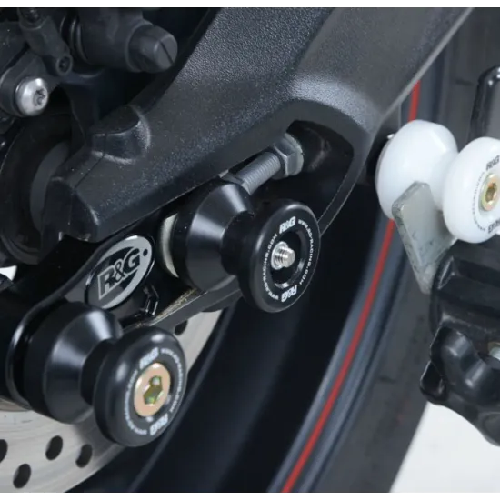 Черни краш тапи R&G Racing монтирани на люлка на Triumph мотоциклет с метална ос и лого на марката