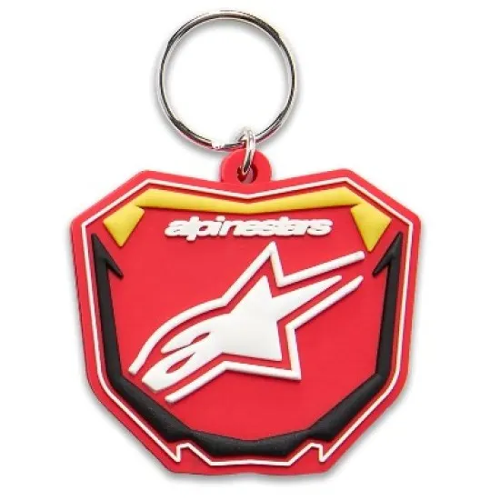 Ключодържател Alpinestars във форма на червен щит с жълти акценти, бяла звезда и черни детайли, с метална халка