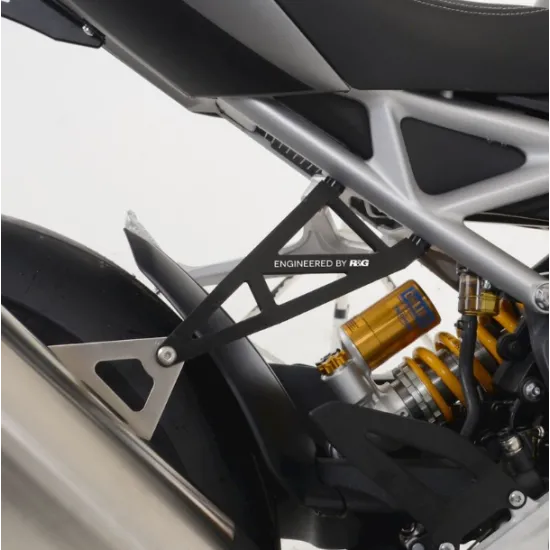 Черен носач за ауспух R&G Racing монтиран на Triumph Speed Triple до жълт Öhlins амортисьор и алуминиева рама с надпис Engineered by R&G