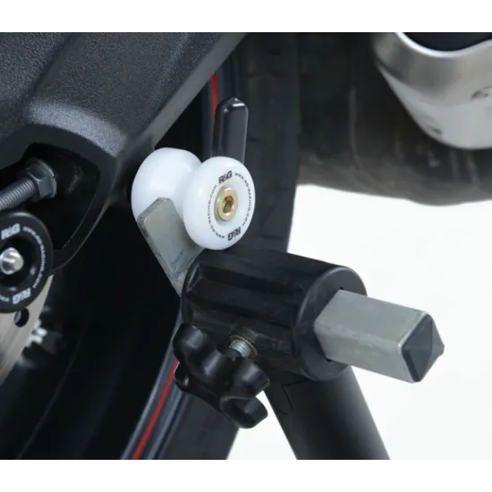 Черни адаптери R&G Racing Stand Bobbins с бяло лого, монтирани на задния шарнир на мотоциклет BMW/Triumph с офсетна пластина