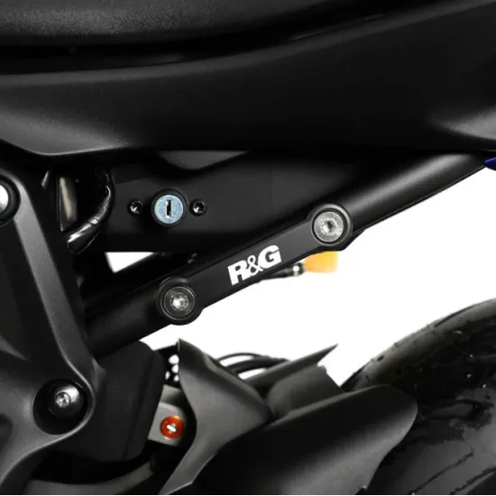 Черна алуминиева плоча R&G Racing, монтирана с два болта на подрамката на Yamaha MT-07, с бяло лого и видим ключалков механизъм в близък план
