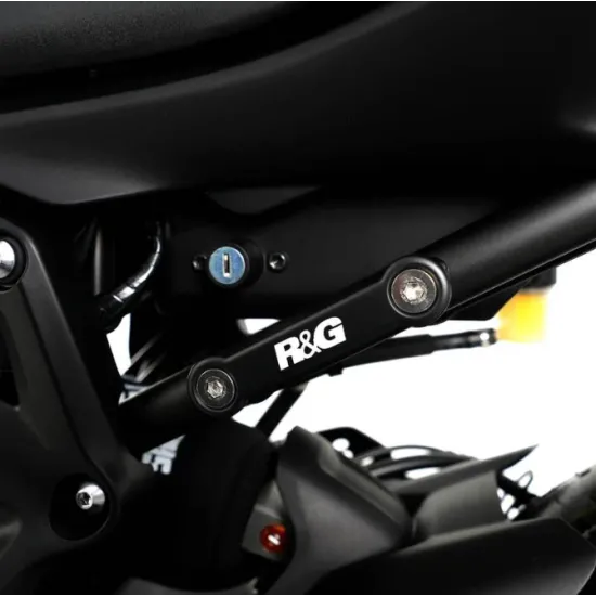 Черна алуминиева плоча R&G Racing, монтирана с два болта на подрамката на Yamaha MT-07, с бяло лого и видим ключалков механизъм в близък план