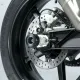 Черни краш тапи R&G Racing монтирани на задната ос на мотоциклет, показани от различни ъгли с видима верига и спирачен диск