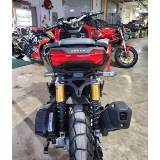 Черна алуминиева стойка за номер R&G Racing на Honda ADV150 с матово покритие, златисти Öhlins амортисьори и компактен носач