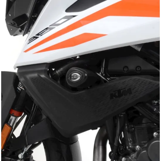 Черни краш тапи R&G Racing монтирани на KTM 390 Adventure с бяло-оранжев дизайн, показващи аеродинамичната капковидна форма и интеграцията с пластмасовите панели