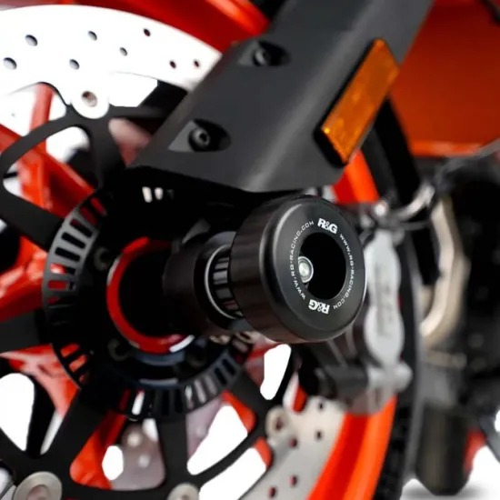Черни CNC алуминиеви краш тапи R&G Racing монтирани на предната ост на оранжев мотоциклет с двойни дискови спирачки