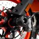 Черни CNC алуминиеви краш тапи R&G Racing монтирани на предната ост на оранжев мотоциклет с двойни дискови спирачки