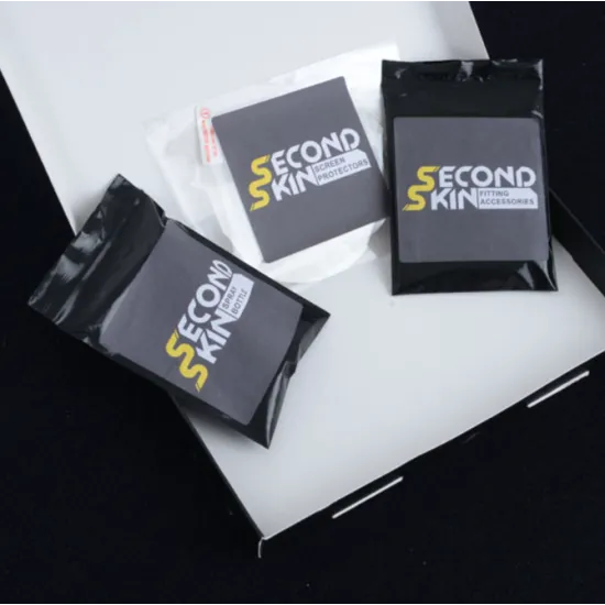 Комплект R&G Racing Second Skin в черна кутия с жълти надписи, включващ прозрачен протектор за екран, мини спрей бутилка, суедна кърпа, микрофибърна кърпа, скрепер и кърпички за почистване