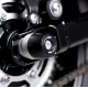 Черни краш тапи R&G Racing монтирани на задната ос на суингарм Triumph, с HDPE ролка и централен болт от неръждаема стомана