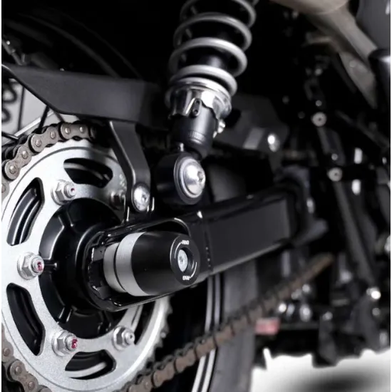 Черни краш тапи R&G Racing монтирани на задната ос на суингарм Triumph, с HDPE ролка и централен болт от неръждаема стомана
