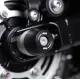 Черни краш тапи R&G Racing монтирани на задната ос на суингарм Triumph, с HDPE ролка и централен болт от неръждаема стомана