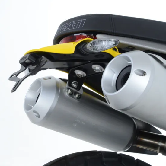 Черна стойка за номер R&G Racing монтирана на Ducati Scrambler 1100 между два сребристи ауспуха и жълт заден калник, с